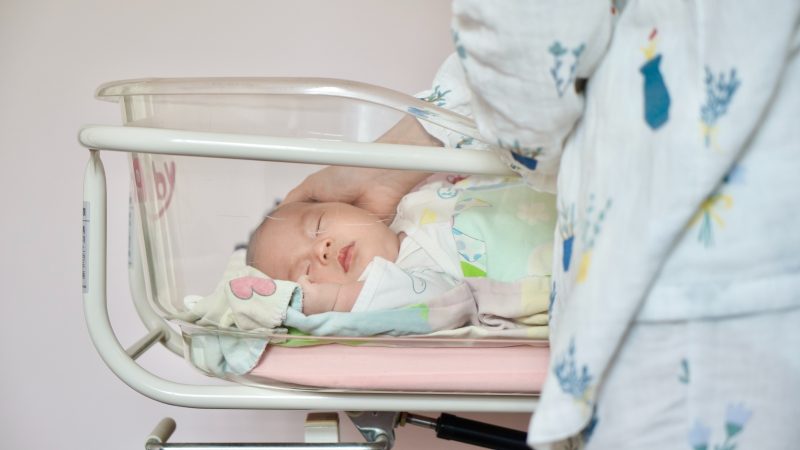 Parent caring for baby in hospital cot