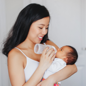 Mother feeding baby formula milk